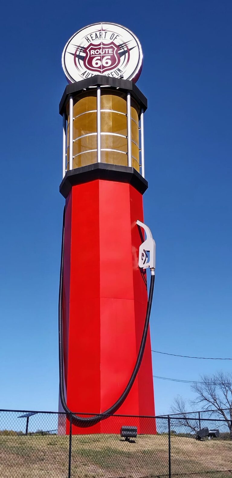 World's Tallest Gas Pump Sapulpa Oklahoma towering 66 feet high with red base, yellow middle section, and circular sign on top against blue sky