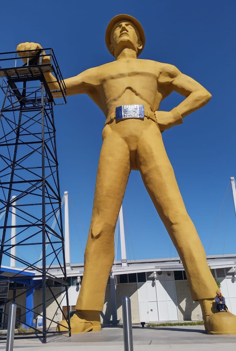 The Golden Driller standing proudly beside an oil derrick in Tulsa, Oklahoma, symbolizing the city’s deep roots in the petroleum industry.