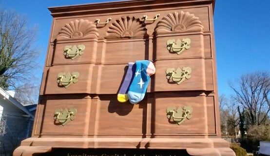 The World's Largest Chest of Drawers towering over the street in High Point, North Carolina, with a pair of colorful socks hanging from an open drawer—a playful nod to the city's furniture industry.