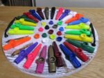 Colorful kazoos arranged in a circle on a round board