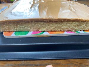 Peanut butter layer spread on yellow cake for homemade Kandy Kakes