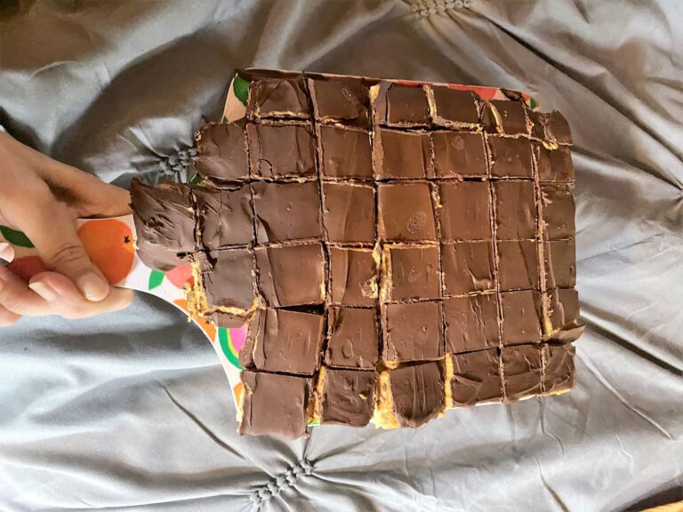 Homemade copycat Kandy Kakes cut into small pieces on a cutting board with uneven chocolate coating