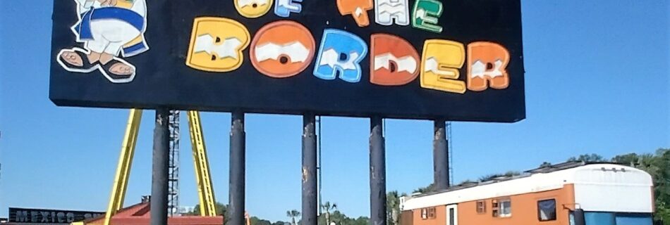 Colorful billboard at South of the Border Road Trip attraction, featuring Pedro in a sombrero and poncho beside an RV, set under a clear Carolina sky.