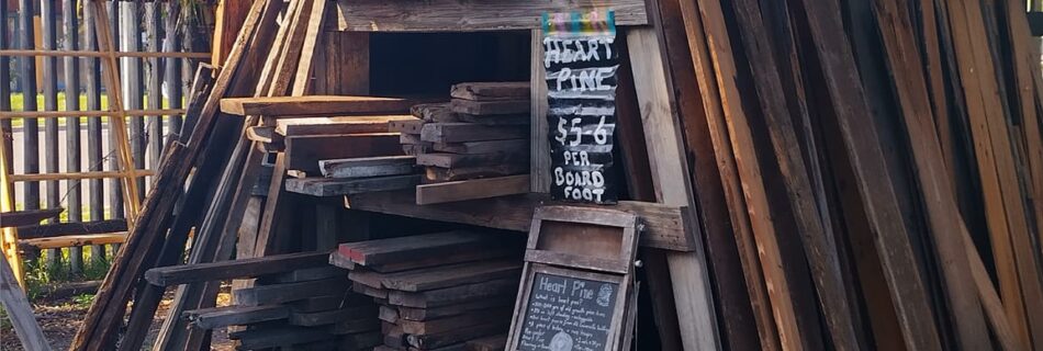 Outdoor reclaimed wood shed at The Repurpose Project in Gainesville, Florida, stocked with heart pine boards and other salvaged lumber for sale.