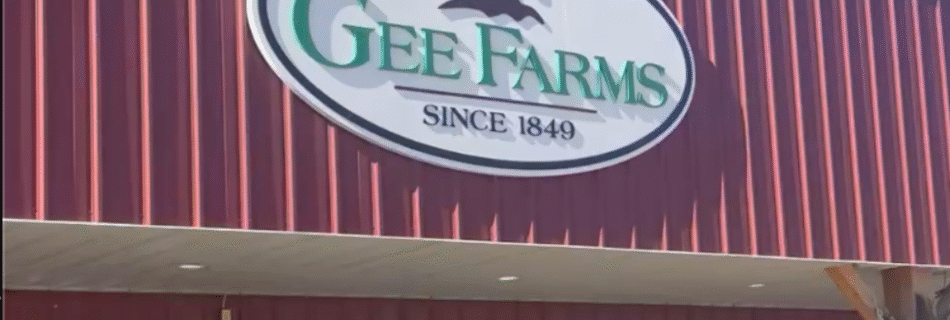 Gee Farms Michigan barn entrance with the Gee Farms sign, red siding, and fall mums — our first Rooted on the Road stop in Michigan.