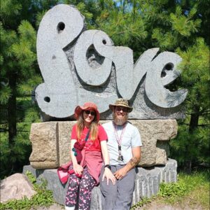 Nancy and Zach sitting at LOVE sculpture during non-romantic date exploring roadside attractions