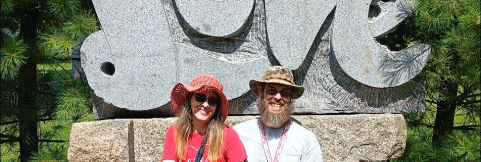 Nancy and Zach sitting at LOVE sculpture during non-romantic date