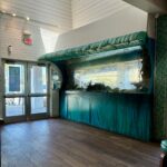 Custom wave-shaped Tanked aquarium built by ATM inside Salt Life Food Shack showing the full 15-foot saltwater tank from inside the restaurant in St. Augustine Beach Florida