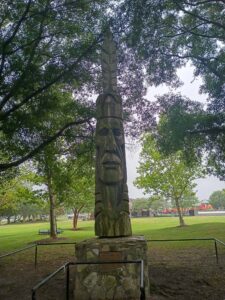 Peter Toth's Whispering Giant sculpture standing beneath trees at Mount Trashmore Park in Virginia Beach, Virginia.