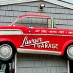 Red vintage Lawyer Garage pickup truck sign mounted above the entrance to the Lawyer Garage collection in Virginia Beach, Virginia.