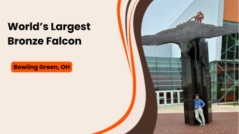 World's Largest Bronze Falcon featured image — Nancy standing beneath the statue outside the Stroh Center in Bowling Green, Ohio