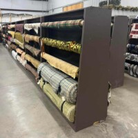 A to Z Gifts Alma Arkansas fabric section showing rolls of material and textiles organized on warehouse-style shelving in the crafting department