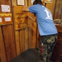Visitor examining wooden display drawers at Call of the Wild museum with specimen collection cabinets