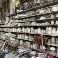 Shelving area at Refab St Louis Repurpose Shop filled with a wide assortment of reclaimed lampshades and light fixtures, including glass, metal, and plastic pieces organized for salvage shopping and creative reuse projects.