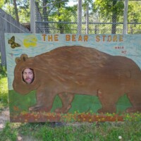 Visitor posing in Bear Store Hale Michigan photo cutout with bear face hole