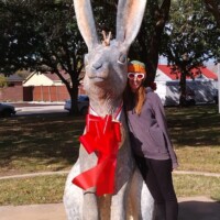 Person giving bunny ears hand gesture behind World's Largest Jackrabbit statue in Odessa Texas