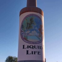 Tulsa’s massive 25-foot Hair Tonic Bottle, towering over the Liquid Life headquarters from a distance