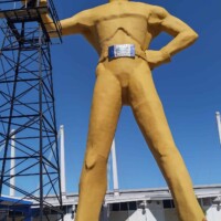 The Golden Driller standing proudly beside an oil derrick in Tulsa, Oklahoma, symbolizing the city’s deep roots in the petroleum industry.