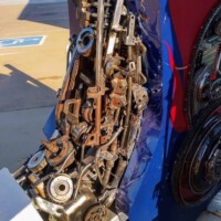 Detail shot of welded metal components from the Optimus Prime statue at G&M Body Shop in Stillwater, Oklahoma. Gears, bolts, and brackets form part of the robot’s torso, painted in red and blue. Industrial textures highlight the craftsmanship behind the Transformers statues Stillwater Oklahoma display.