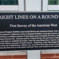 Historical plaque titled 'Straight Lines on a Round World' about the first survey of the American West