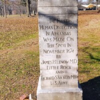 Granite monument in MacArthur Park inscribed with names of James H. Lenow, M.D. and Richard S. Vickery, M.D. — marks Arkansas’s first legal human dissection in 1874.