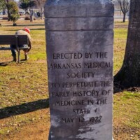 Granite monument in MacArthur Park inscribed with dedication from the Arkansas Medical Society — erected May 13, 1927 to honor the early history of medicine in the state.