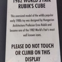 Informational sign about the 1982 World’s Fair Rubik’s Cube sculpture, detailing its origins as a Hungarian pavilion exhibit and noting it was designed by Professor Erno Rubik.