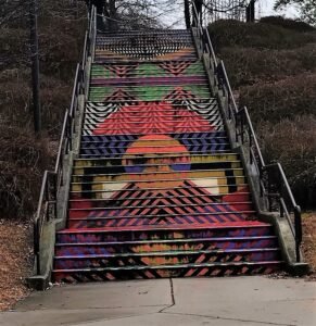 Close-up of a staircase painted with colorful zigzag and geometric patterns