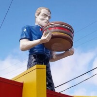 Statue of a smiling man in blue shirt holding giant burger on rooftop of Pal’s Sudden Service at 4224 Fort Henry Drive, Kingsport, TN.
