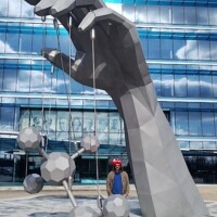 Giant hand holding molecules sculpture Johnson City with visitors for scale