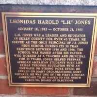 A commemorative plaque honoring Leonidas Harold 'L.H.' Jones, detailing his legacy as an educator and leader in Surry County. The plaque highlights his role as the principal of J.J. Jones High School for its entire 30-year existence and his dedication to preparing African American students with life skills and a strong work ethic. It also notes his appointment to the North Carolina Board of Elections as one of the first African Americans to serve.