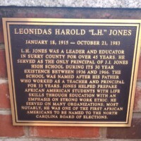 A commemorative plaque honoring Leonidas Harold 'L.H.' Jones, detailing his legacy as an educator and leader in Surry County. The plaque highlights his role as the principal of J.J. Jones High School for its entire 30-year existence and his dedication to preparing African American students with life skills and a strong work ethic. It also notes his appointment to the North Carolina Board of Elections as one of the first African Americans to serve.