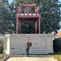 The World's Largest Duncan Phyfe Chair in Thomasville, NC—a towering replica standing atop a stone pedestal with engraved details, surrounded by trees and buildings