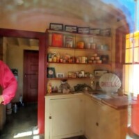 A nostalgic interior view of the Shell-shaped gas station, featuring a cozy kitchen area with storage shelves, a microwave, and decorative collectibles reflecting its history.