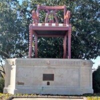 The World's Largest Duncan Phyfe Chair in Thomasville, NC—a grand red chair with intricate twisted legs and a decorative backrest, standing on a stone pedestal with a commemorative plaque