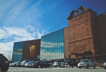 Modern glass building designed to look like the World's Largest Highboy Dresser with traditional brick tower section, located at Furnitureland South