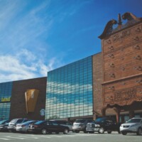 Modern glass building designed to look like the World's Largest Highboy Dresser with traditional brick tower section, located at Furnitureland South