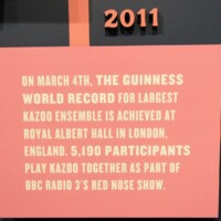 Informational sign from 2011 describing the Guinness World Record for Largest Kazoo Ensemble—5,190 participants playing kazoo at Royal Albert Hall in London as part of BBC Radio 3’s Red Nose Show.