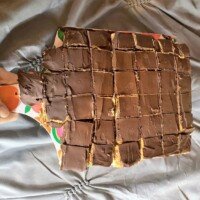 Homemade copycat Kandy Kakes cut into small pieces on a cutting board with uneven chocolate coating