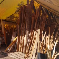 Outdoor lumber storage tent at The Repurpose Project in Gainesville, Florida, filled with reclaimed wood planks, irregular boards, and a “Free Stuff” section for salvaged materials.