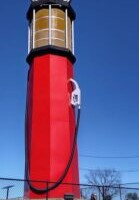 World's Tallest Gas Pump replica at Heart of Route 66 Auto Museum in Sapulpa, Oklahoma — red vintage-style structure with Route 66 signage, person standing at base for scale
