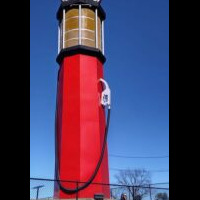 World's Tallest Gas Pump replica at Heart of Route 66 Auto Museum in Sapulpa, Oklahoma — red vintage-style structure with Route 66 signage, person standing at base for scale