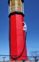 Person standing next to World's Tallest Gas Pump in Sapulpa Oklahoma showing massive scale of 66-foot roadside attraction