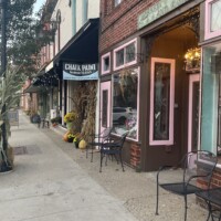 Charming downtown Holly Michigan storefronts decorated for fall with pumpkins, corn stalks, and vintage signage along Battle Alley