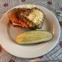 Plate at The Laundry Restaurant in Fenton Michigan with #53 Mumford’s Quest sandwich featuring housemade meatballs, Provolone, Parmesan, red onions, banana peppers, Italian pesto, and marinara on grilled French bread, served with pickle spear