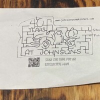 A small paper map for Johnson’s Pumpkin Farm corn maze. The map design shows a pickup truck carrying a pumpkin and includes the text “40 Years at Johnson’s.” A QR code at the bottom provides maze assistance, and the words “Start” and “Finish” are marked on the right side.