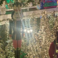 Large nutcracker display surrounded by glittering Christmas trees and colorful holiday decorations at Christmas Winter Wonderland in Fort Smith, Arkansas.