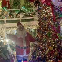 Santa Claus figure surrounded by glowing Christmas trees, wrapped presents, and holiday decorations at Christmas Winter Wonderland in Fort Smith, Arkansas.