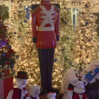 Large nutcracker statue surrounded by Christmas trees, snowman figures, and holiday decorations inside Christmas Winter Wonderland in Fort Smith, Arkansas.