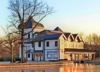 Neosho Fish Hatchery Building in winter with frozen lake in front.
